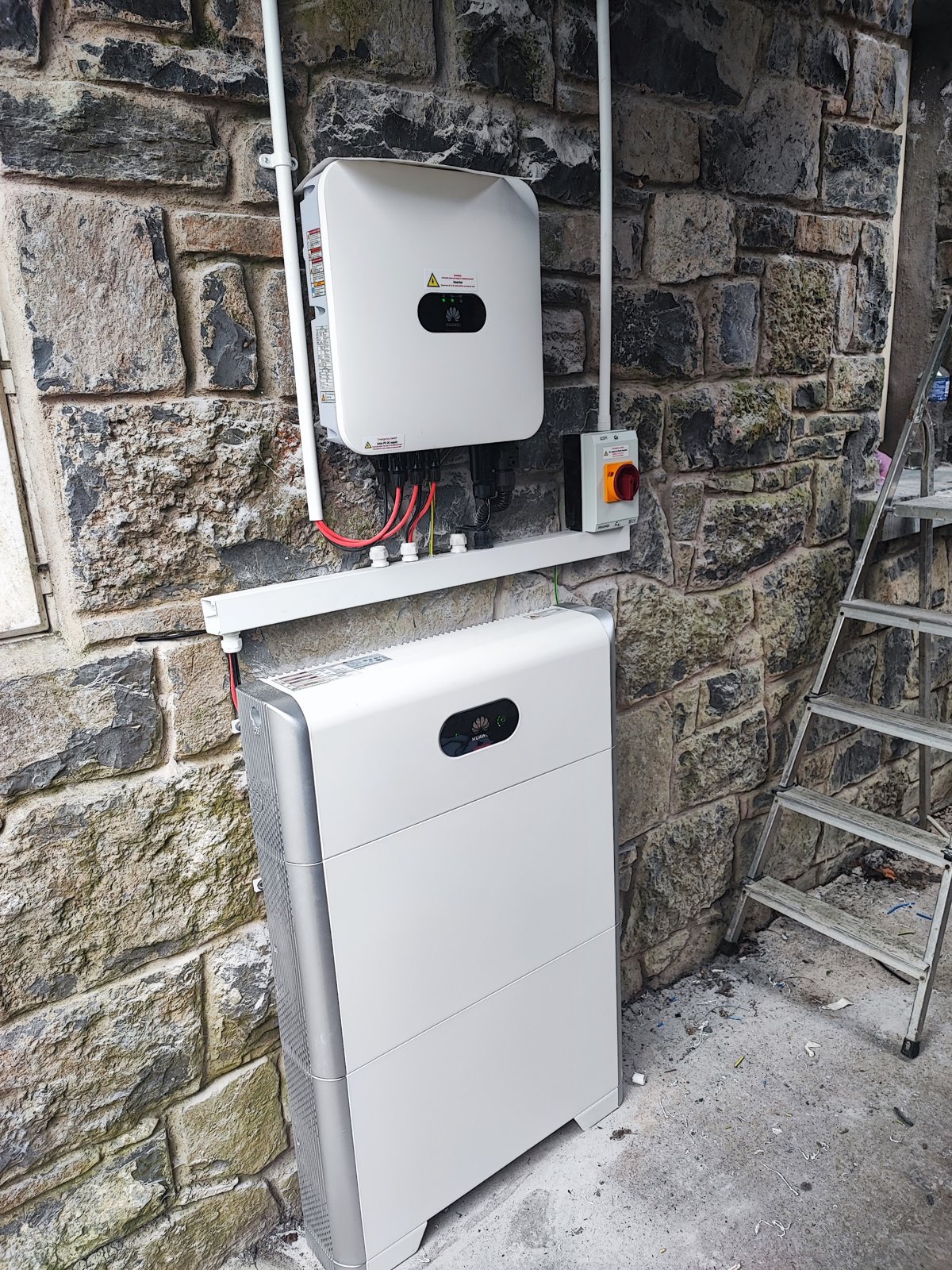 An inverter and battery unit on a stone wall