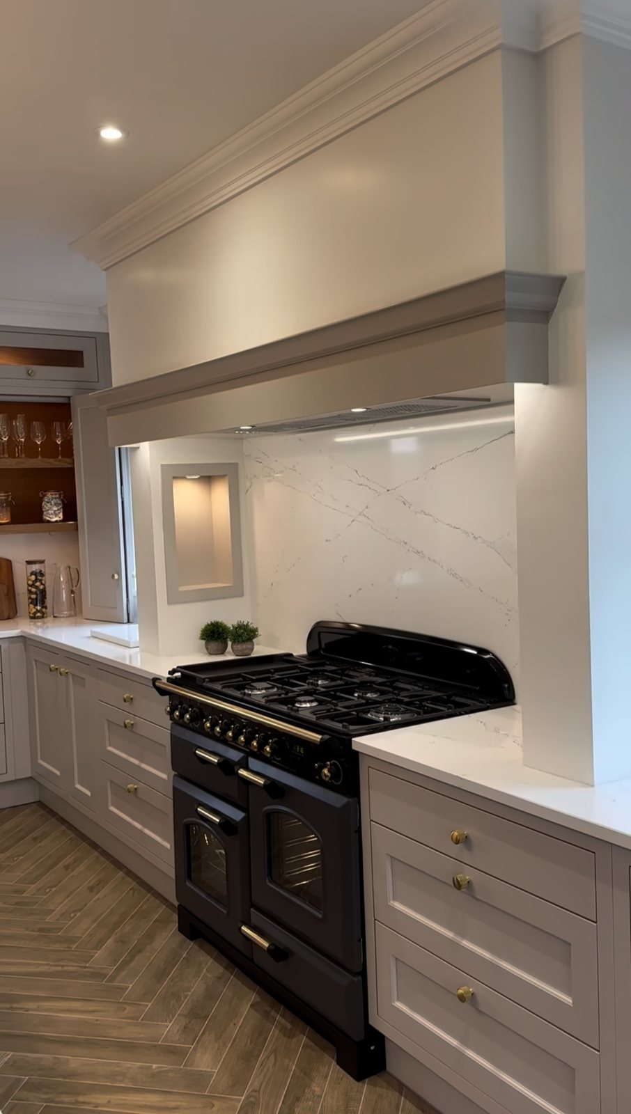 A kitchen with a range cooker and lit niches